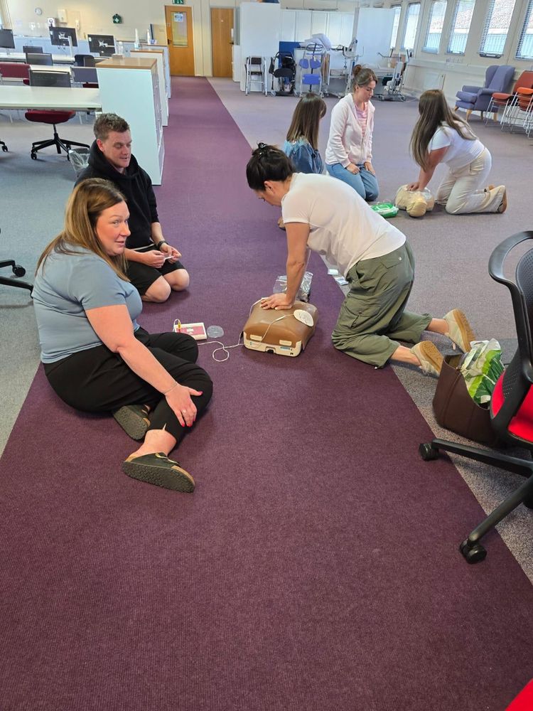 Group of staff practising CPR during on-site first aid training