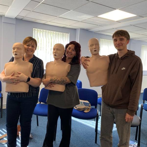 Delegates practising CPR on training manikins during an on-site first aid course
