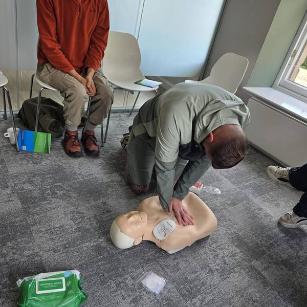 Trainee performing CPR with an AED defibrillator during workplace first aid training